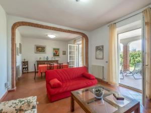 a living room with a red couch and a table at Holiday Home Podere Chiocciolaia by Interhome in Podere Cernaia