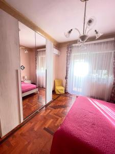 Dormitorio con espejo y cama rosa en Casa Vacanza La Isla Bonita, en Isola delle Femmine