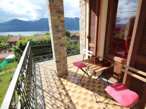 einen Balkon mit rosa Stühlen und Blick auf das Wasser in der Unterkunft Holiday Home di Elsa by Interhome in Brezzo