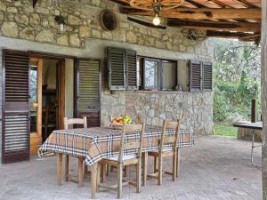 un tavolo e sedie di fronte a una casa in pietra di Holiday Home Casale Ulisse by Interhome a Roccastrada