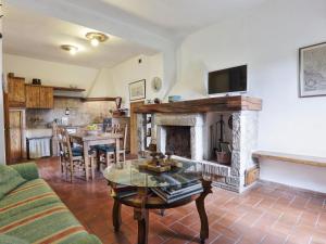 a living room with a fireplace and a table at Holiday Home Casale Ulisse by Interhome in Roccastrada