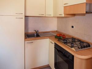 eine Küche mit weißen Schränken, einer Spüle und einem Herd in der Unterkunft Studio Adriatico-1 by Interhome in San Silvestro