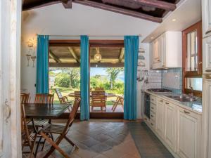 a kitchen with a table and a dining room at Holiday Home Gardenia by Interhome in Pittulongu +26 photos