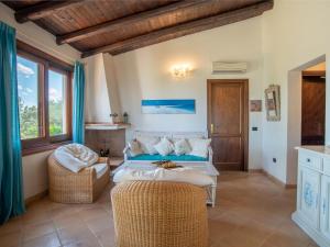 a bedroom with a bed and two chairs in a room at Holiday Home Gardenia by Interhome in Pittulongu