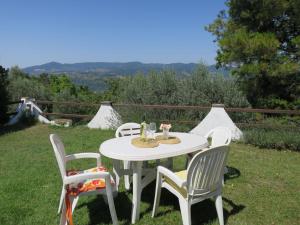 un tavolo bianco e sedie in erba di Holiday Home Ulivo by Interhome a Montescudaio