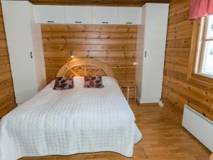 a bedroom with a bed with a wooden wall at Holiday Home Luppo-koli - laferte 1 by Interhome in Kolinkylä