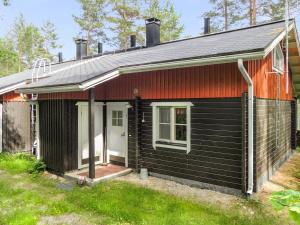 mały czarny dom z białymi drzwiami w obiekcie Holiday Home Luppo-koli - laferte 1 by Interhome w mieście Kolinkylä
