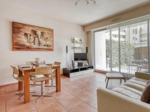 a living room with a table and a couch at Apartment Les allées du Cap-3 by Interhome in Antibes
