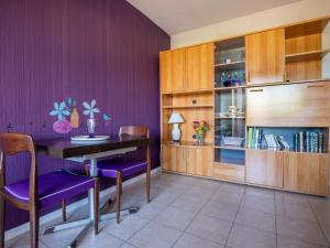une salle à manger avec des murs violets et une table et des chaises en bois dans l'établissement Apartment Plein Soleil-2 by Interhome, à Arcachon