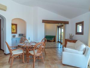 ein Wohnzimmer mit Tisch und Stühlen und einer Couch in der Unterkunft Holiday Home Corbezzolo 8 - Vista Village by Interhome in Porto San Paolo