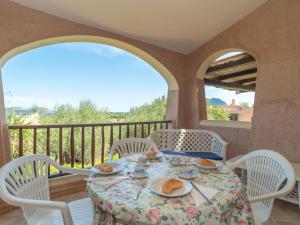 a table with plates of food on a balcony at Holiday Home Dalia 19 - Vista Village by Interhome in Porto San Paolo