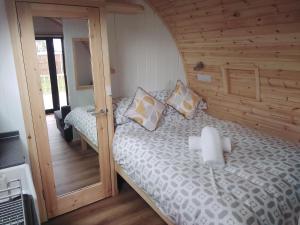 a bedroom with a bed with a wooden wall at Glamping Pods in Cromer