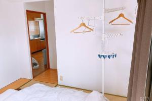 a room with a white wall with hangers at Esperanza 204号室 in Tokyo