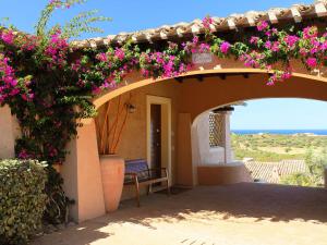 a house with flowers on the side of it at Holiday Home Corbezzolo 9 - Vista Village by Interhome in Porto San Paolo