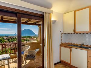 a kitchen with a view of a balcony at Holiday Home Corbezzolo 9 - Vista Village by Interhome in Porto San Paolo +24 photos