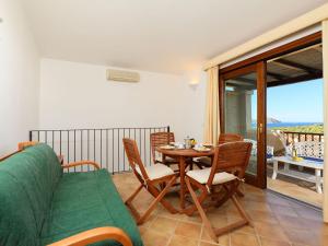 a living room with a couch and a table and chairs at Holiday Home Corbezzolo 9 - Vista Village by Interhome in Porto San Paolo