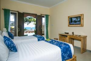 Ashyana Candidasa Beach Resort في كانديداسا: غرفة نوم بسريرين وإطلالة على المحيط