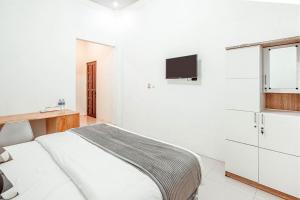 Tempat tidur dalam kamar di Krisan Guest House Syariah Mitra RedDoorz