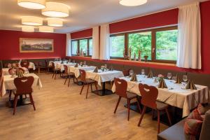 a dining room with tables and chairs and windows at River Hotel Post in Chienes