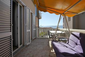 einen Balkon mit einem Tisch, Stühlen und einem Sonnenschirm in der Unterkunft Apartments Babaja in Omiš