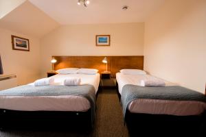a hotel room with two beds and two lamps at Bank Street Lodge in Fort William