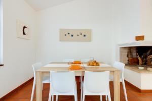a dining room with a table and white chairs at Villa Viola in Narbolia