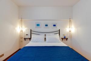 ein Schlafzimmer mit einem blauen und weißen Bett mit zwei Lichtern in der Unterkunft Villa Viola in Narbolia