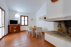 a kitchen and dining room with a table and a fireplace at Villa Viola in Narbolia