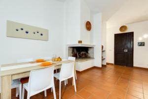 a kitchen with a table and chairs and a fireplace at Villa Viola in Narbolia