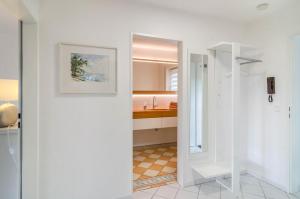 een witte badkamer met een wastafel en een spiegel bij Ferienwohnung Lux in Überlingen