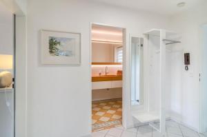 a white bathroom with a sink and a mirror at Ferienwohnung Lux in Überlingen
