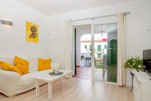 uma sala de estar com um sofá branco e uma mesa em Pregonda 13 Menorca em Son Parc