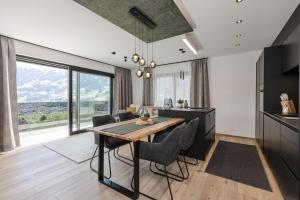 a kitchen and dining room with a table and chairs at Grand Alpin Panorama Lodge Top 3 in Hart im Zillertal