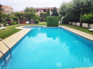 - une piscine d'eau bleue dans la cour dans l'établissement Apartamentos Revolta Sanxenxo 3000, à Revolta