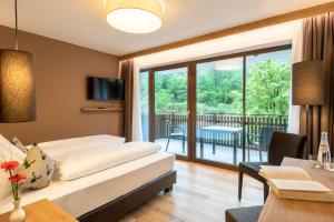 a hotel room with a bed and a balcony at River Hotel Post in Chienes +30 photos