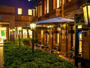 a restaurant with tables and umbrellas in front of a building at Hotel Ace Morioka in Morioka