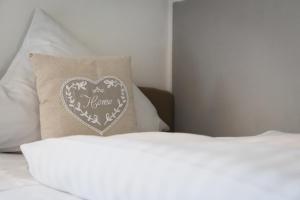 a bed with a pillow with a heart on it at Hotel Kattenbeck in Allersberg