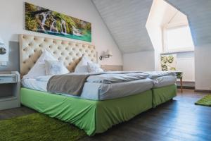a bedroom with a large bed with a large headboard at Hotel Kattenbeck in Allersberg