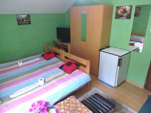 a small room with a bed and a small refrigerator at Apartman MILENA in Foča