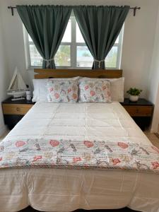 a bedroom with a large bed with two windows at Luna Bay Breeze in Marathon