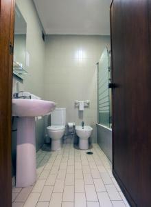 een badkamer met een wastafel, een toilet en een wastafel bij Riabela Inn in Torreira