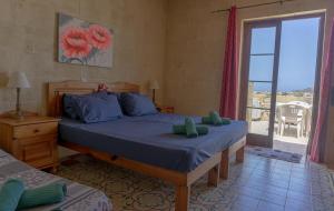 Un pat sau paturi într-o cameră la Ta' Lorenzo Farmhouse