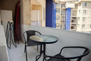 una mesa y sillas en el balcón de un edificio en Sunny apartments. Tbilisi. 300 Aragveli, en Tiflis