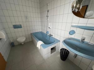 a bathroom with a blue tub and a sink at Gästehaus Trink B&B in Drobollach am Faakersee