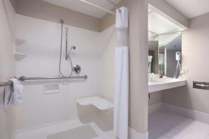 a bathroom with a tub, toilet and sink at 41 Lakefront Hotel, Trademark Collection by Wyndham in Geneva