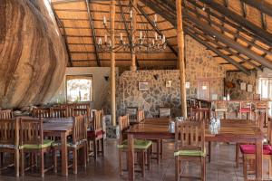 MatoposBig Cave Camp的配有木桌椅的餐厅