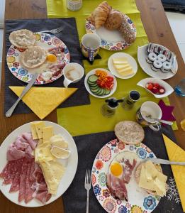 a table topped with plates of food and eggs and cheese at Gästehaus Trink B&B in Drobollach am Faakersee