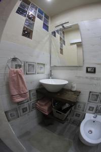 a bathroom with a sink and a toilet and a mirror at Lightroom in Fenis