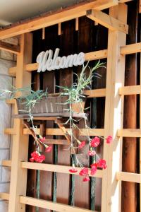 a sign on a wooden wall with red flowers at 238 Spodnje Gorje in Spodnje Gorje