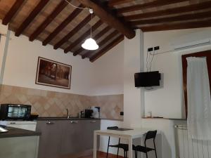 a kitchen with a table and a white table and chairs at La casa in giardino in Volterra